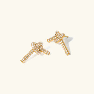 18K gold pavé knot diamond stud earrings flat lay top-down view showcasing full crystal rhinestone coverage and polished gold finish