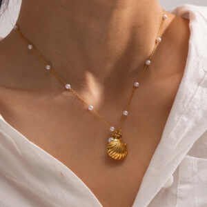 Pearl seashell gold necklace worn on female model with white shirt neck close-up styling