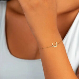 Delicate 18K gold moon bracelet worn on woman's wrist with thin elegant chain and minimalist lunar pendant
