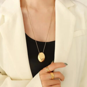 Minimalist 18K gold necklace worn on model's collarbone close-up detail shot with dainty fine chain and polished pendant