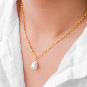 pearl drop necklace worn on model with white collared shirt showing gold cable chain and teardrop pearl at collarbone close-up