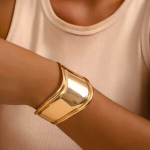 18K gold open cuff bracelet worn on female wrist close-up side view with nude tank top