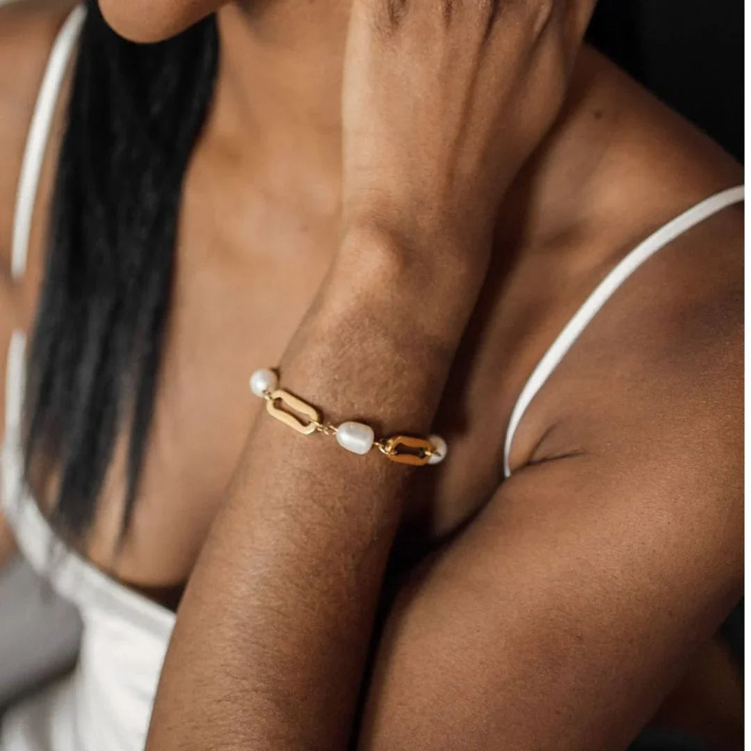 18K gold pearl bracelet worn on wrist close-up forearm shot mixed link and pearl design elegant styling