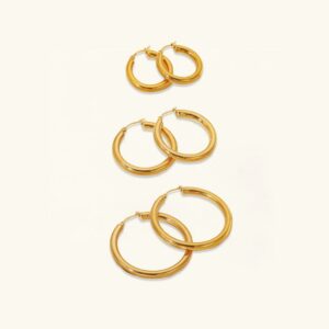 18K gold wide hoop earrings three-pair collection in small medium and large sizes on white background flat lay