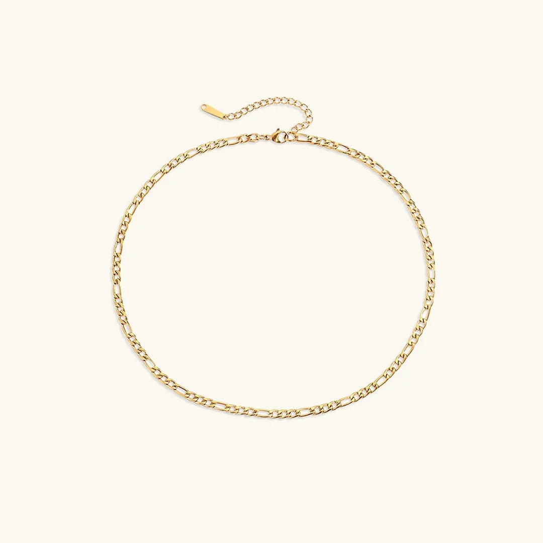 Figaro gold chain necklace 4mm width flat lay with lobster clasp and extender chain on light background