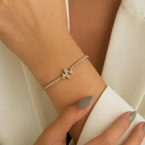 Heartbeat pulse bracelet worn on female wrist with 18K gold finish and crystal pave details lifestyle shot