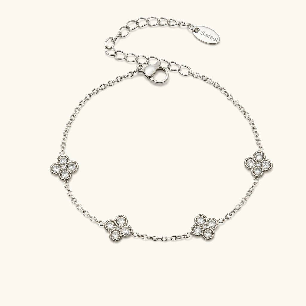Sterling silver four-leaf clover bracelet with diamond simulant gemstone charms, luxury jewelry flat lay