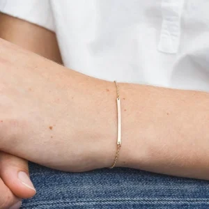14k gold bar bracelet worn on wrist close-up side view showing slim fit and polished gold finish paired with casual daily outfit