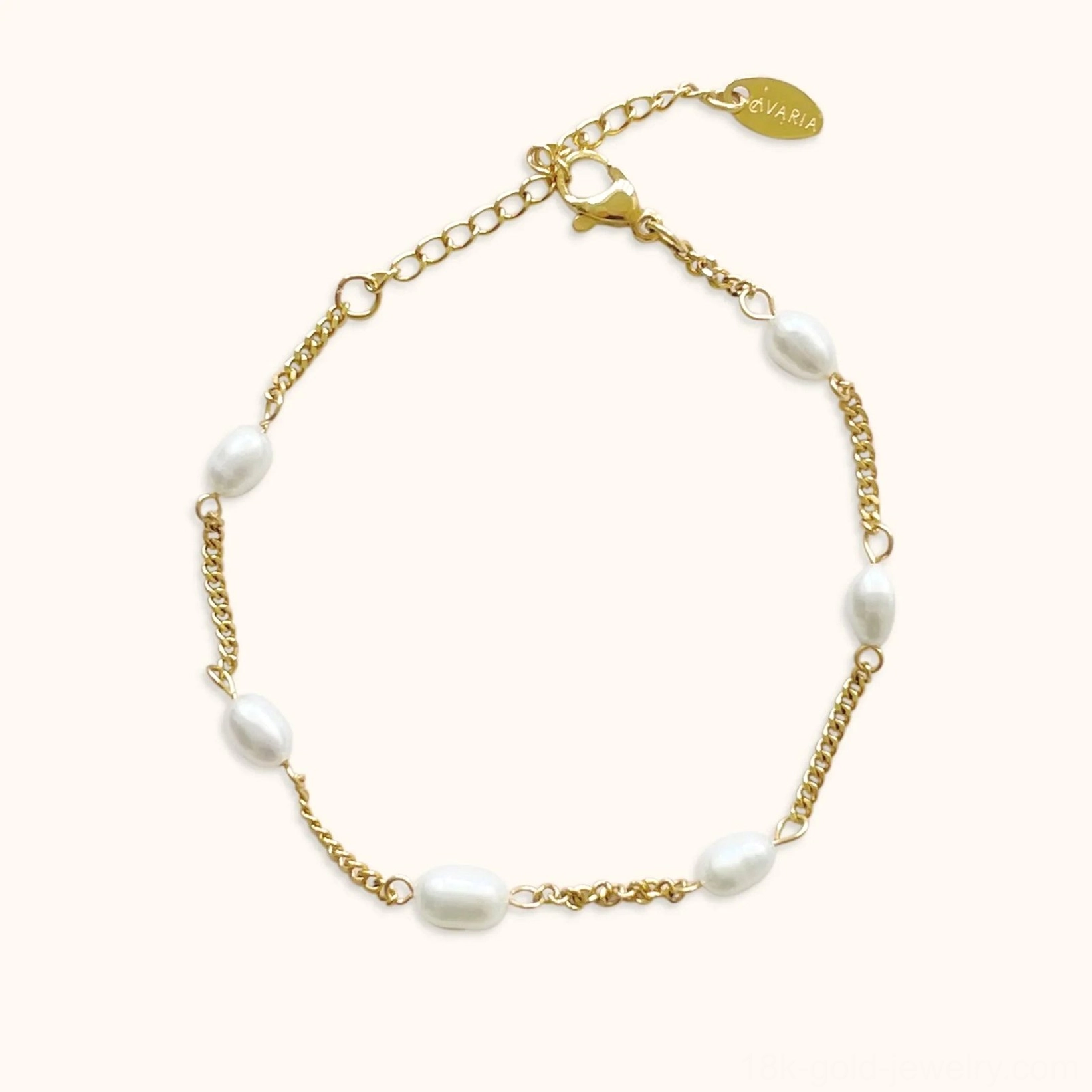 14K yellow gold freshwater pearl bracelet flat lay front view on neutral background featuring oval rice-shaped pearls clustered with delicate gold curb chain and adjustable extension charm