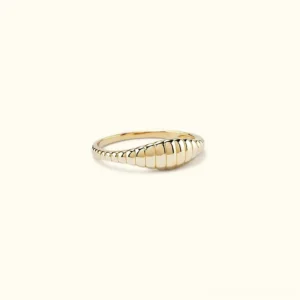 14K gold ribbed dome ring flat lay frontal view showing polished segmented curved texture on light background