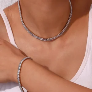 Silver-toned baguette tennis choker necklace with matching bracelet worn on model with white tank top showing neck and wrist styling