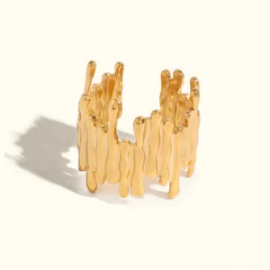 18K gold abstract ring with molten stripe design in bright yellow gold flat lay on plain backdrop