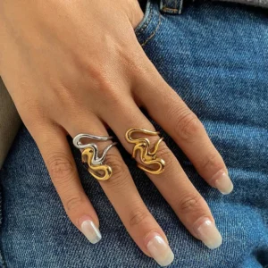 Two abstract swirl gold rings on hand close-up worn dual-tone and solid gold finish contemporary style