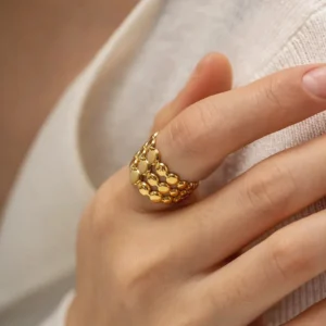 18K gold beaded open ring worn on female finger, adjustable cuff fit demonstration with white fabric background