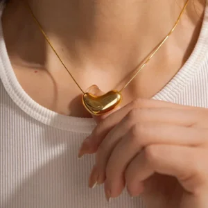 18K gold bean pendant necklace worn on neck close-up shot woman white tank top delicate layerable design