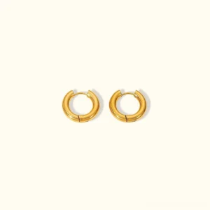18K gold bold round hoop earrings with smooth polished finish displayed on white background flat lay product photography