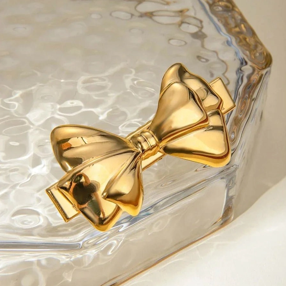 18K gold bow hair clip side view oblique angle glass display polished metal finish