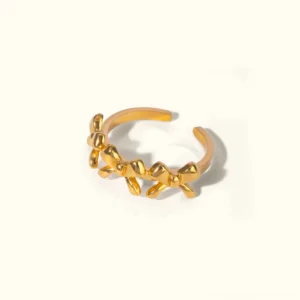 18K gold bow ring with three-dimensional bow accents, adjustable open band, polished finish on neutral background, top-down front view