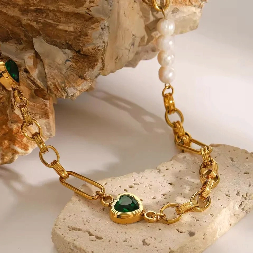 18K gold pearl bracelet with emerald accent stones texture close up