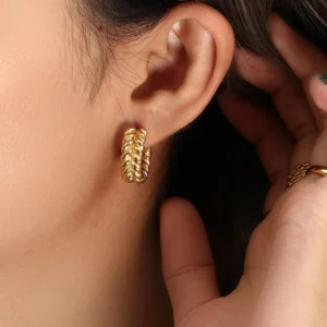 Close-up side view of 18K gold braided hoop earrings on model ear demonstrating perfect fit and luxurious golden finish