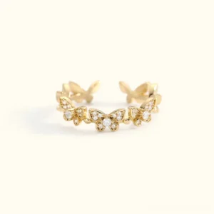 18K gold butterfly ring adjustable open band with crystal diamond simulants flat lay overhead view