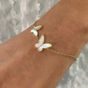 18K gold butterfly bracelet worn on wrist showing white mother-of-pearl butterfly details and gold-toned hardware close-up