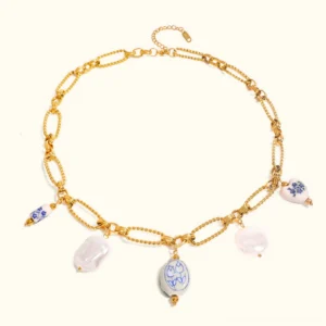 18K gold cerulean freshwater pearl necklace with blue-and-white porcelain charms displayed flat lay on plain white background showing dual gold chains and baroque pearls