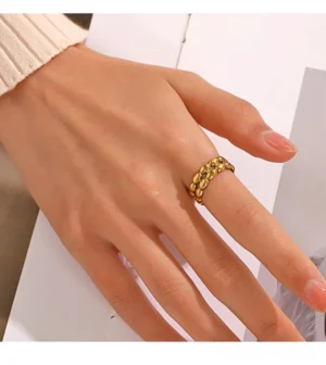 18K gold chain cuff ring on female hand - close-up jewelry photography minimalist background
