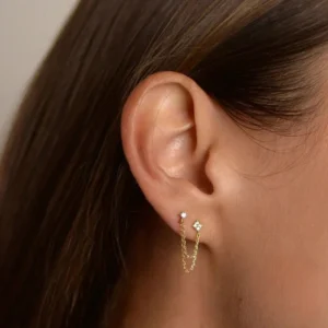 18K gold chain stud earrings worn on ear close-up side view delicate gold plating and layered chains