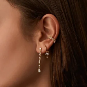 18K gold charm hoop earrings modeled on ear with crystal sparkle styling