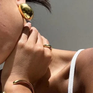 18K gold bean earrings worn on model ear close-up side view hypoallergenic stainless steel