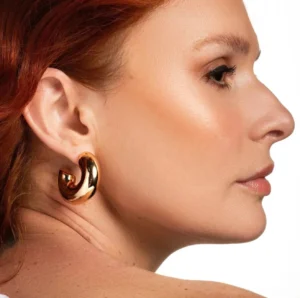 Gold chunky hoop earrings on model profile view red hair female wearing statement earrings
