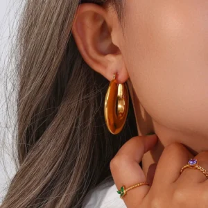 18K gold chunky hoop earrings worn on ear close-up view glossy gold finish elegant ear styling