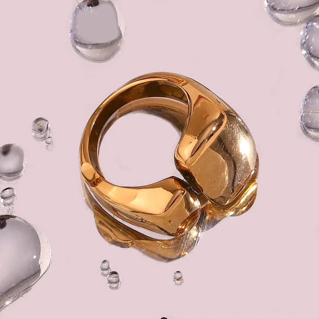 Chunky 18K Gold open ring with overlapping geometric blocks, top-down flat lay on water droplet background showcasing high-shine polished finish