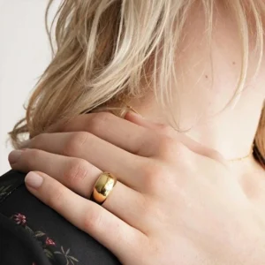 18K gold ring worn on middle finger close-up side view glossy golden finish on model hand