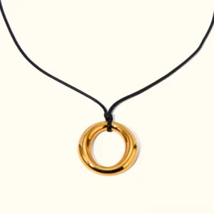 18K gold open circle pendant necklace flat lay front view with polished gold ring charm and black waxed rope cord on light background