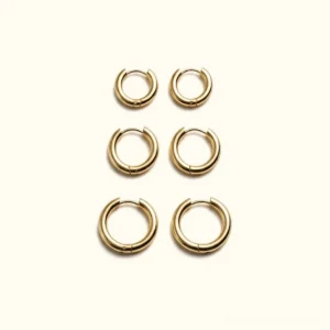 18K gold classic round hoop earrings set of three sizes flat lay overhead view polished metal hinged clasp
