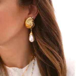 18K gold conch pearl earrings worn on model ear, side view showing elegant dangling pearl accent with casual brown hair styling