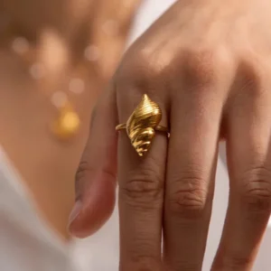 Adjustable 18K gold conch ring worn on female hand close-up detail showing polished finish
