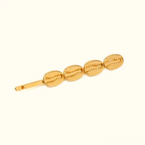 18K gold cowrie shell hair pin front view on white background, polished golden finish with four shell charms, luxury bobby pin accessory