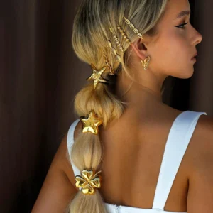 Gold hair accessories worn on blonde woman's braided ponytail, mixed styles including star and clover designs, side back view styling