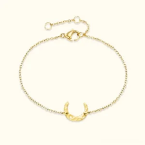 18K gold crescent moon chain bracelet flat lay featuring hand-hammered lunar charm and delicate cable chain design