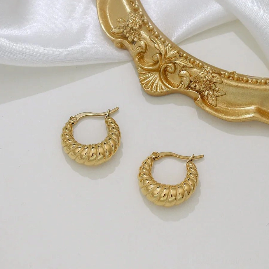 18K gold croissant hoop earrings close-up showing smooth metallic finish and twisted ridge details
