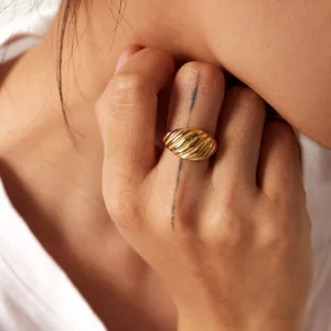 18K gold croissant ring worn on hand middle finger close-up side view ridged curved design detail