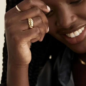 18K gold croissant ring worn on hand close-up detail twisted ridges black model indoor
