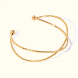 18K gold crossed cuff bracelet flat lay top view with crossed open-ended bands and polished gold finish