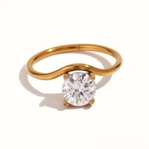 Curved solitaire diamond 18K gold ring front flat lay view, round brilliant stone with four-prong setting and elegant wave band on white background