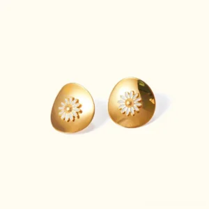 18K gold daisy stud earrings front flat lay view with polished oval base and white enamel daisy flower ornament on plain beige background
