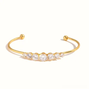 18K gold diamond cuff bracelet with graduated round cubic zirconia stones, top-down flat lay view showing full stone arrangement