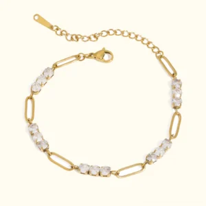 18K gold diamond paperclip bracelet with cubic zirconia stones flat lay on plain background